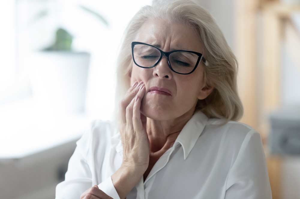 Woman holding mouth in pain