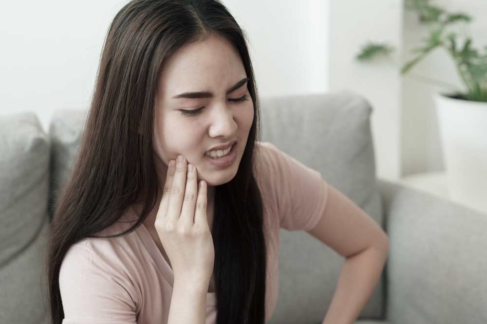 Woman holding face in pain