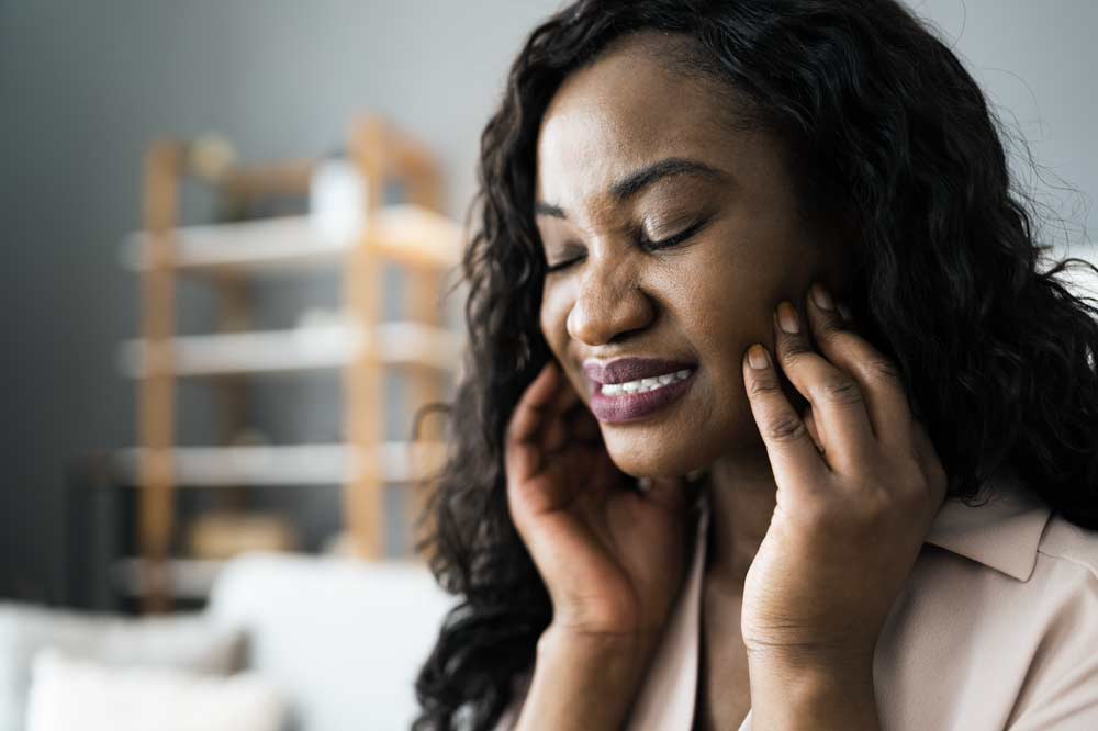 Woman holding face in pain