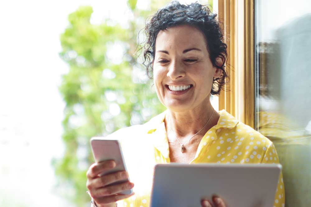 Woman smiling while looking at phone